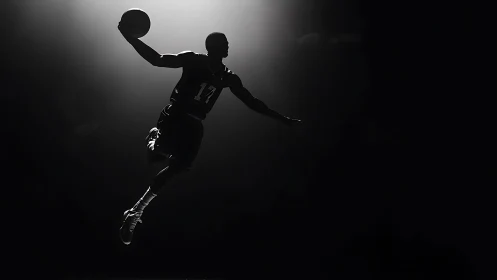 Silhouetted basketball player captured midair under focused backlight
