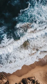 Waves crash against golden shoreline in aerial seascape.