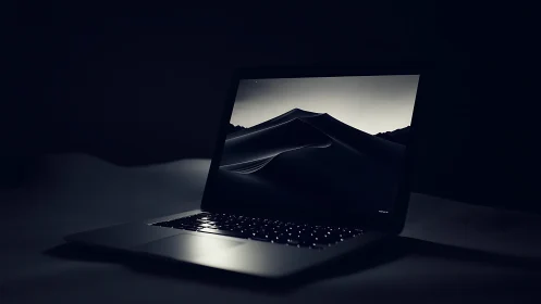 Midnight laptop glow with quiet desert dreamscape screen.