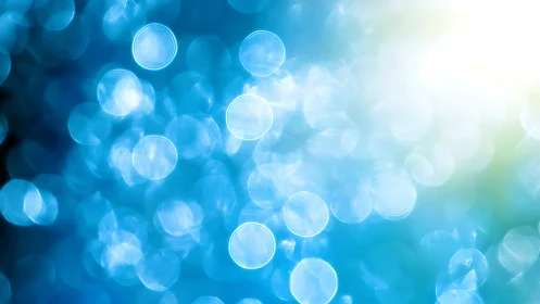 Blue bokeh light orbs glow against soft radiant background.