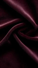 Deep burgundy velvet fabric shows folded draped surface