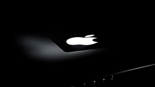 Apple logo illuminated on device display against dark environment