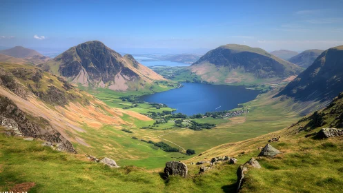 Mountain valley with lake, green fields and distant horizon.
