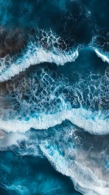 Top view of crashing ocean waves in deep blue water.
