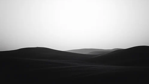Gentle desert dunes resting under a quiet silver sky.