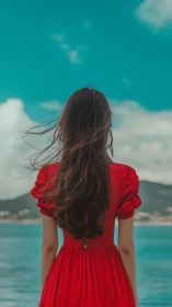 Gentle ocean breeze welcomes a woman in a flowing red dress