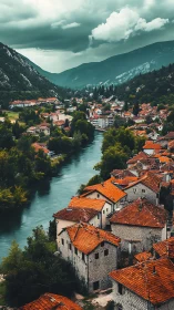 River valley town with red roofs under overcast sky.