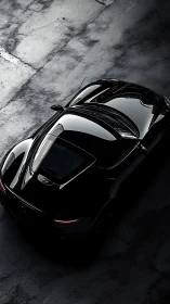 Black sports car on textured concrete surface at night.