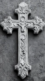 Stone relief cross with ornate floral detailing on wall.