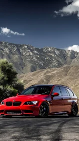 Red sports wagon stands bold beneath rugged mountain skyline.