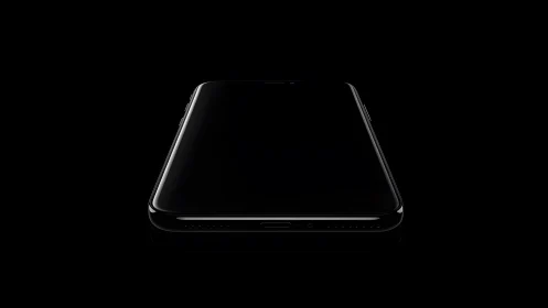 Sleek modern smartphone in dramatic black minimalist lighting.