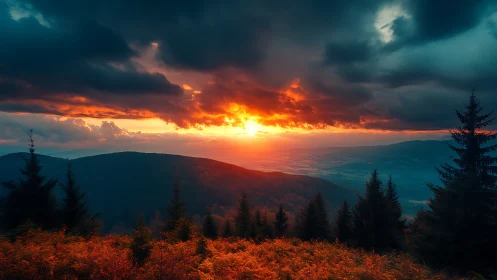 Fiery sunset over dark forested mountains and valley.