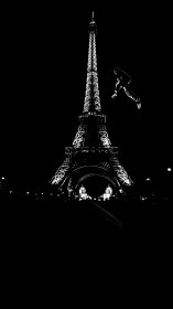 Silhouetted Eiffel Tower at night with floating figure.