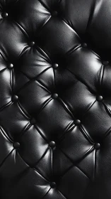 Close-up diamond-tufted black leather upholstery surface