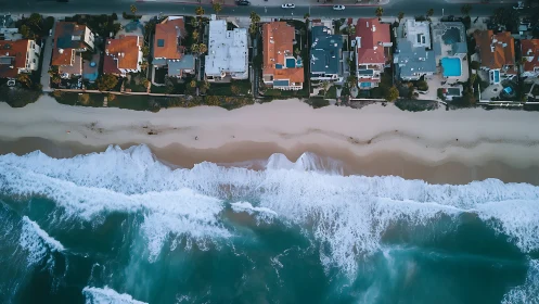 Aerial coastal housing grid aligned against high energy surf