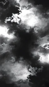 Storm-torn monochrome clouds circling a shadowed void skyward.