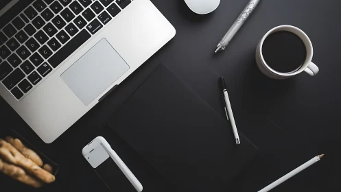 Organized desktop layout with laptop, coffee and devices.