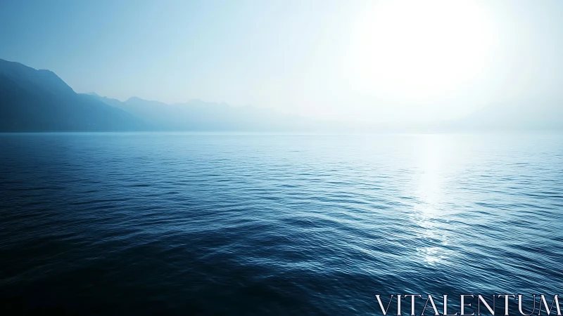 Calm blue sea under bright sun with distant hazy mountains.
