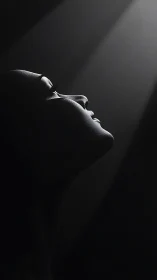Monochrome profile silhouette under single dramatic light.