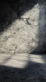 Concrete wall and floor with directional light shadow pattern.