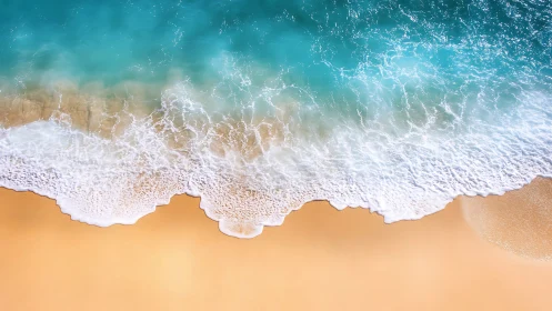 Overhead shoreline wave dynamics with foamy surf on smooth sand