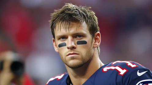 Focused football player stands ready in bold navy uniform