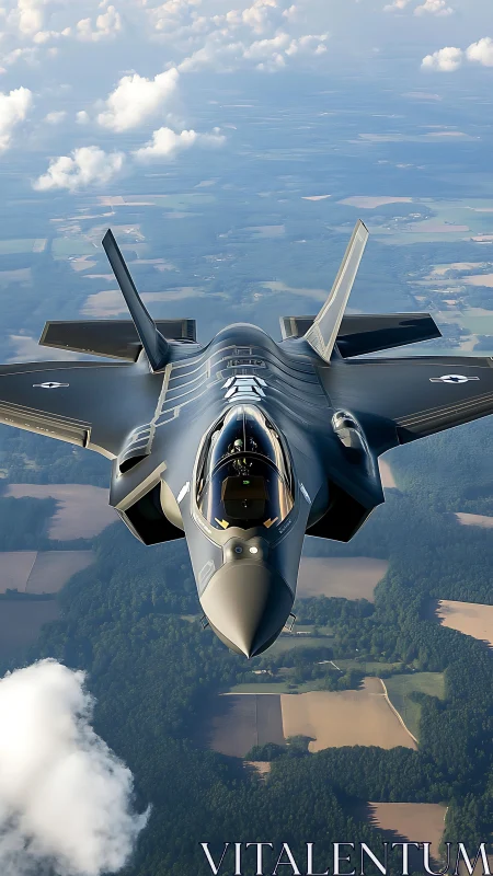 Stealth fighter jet cuts through clouds above patchwork fields.