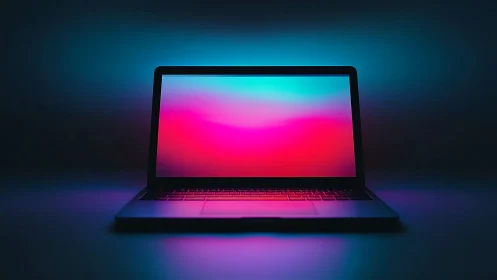 Laptop screen displays gradient colors under low-key lighting