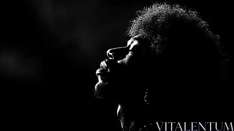 Silhouetted profile portrait in dramatic low key light.