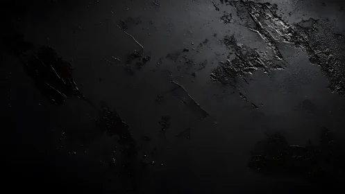 Dark textured surface with irregular reflective patches.