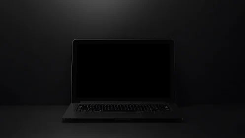 Minimalist black laptop on dark seamless studio backdrop.