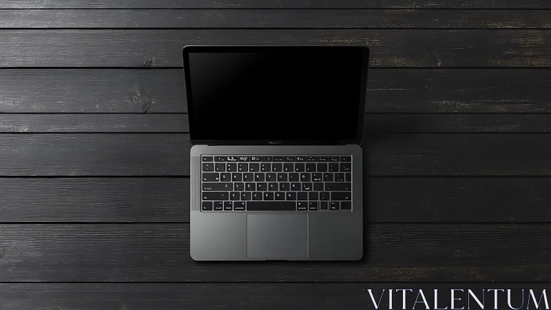 Open laptop centered on dark wooden plank surface.