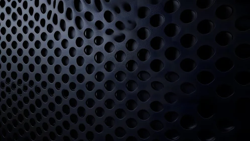 Dark perforated metal sheet with abstract geometric pattern.
