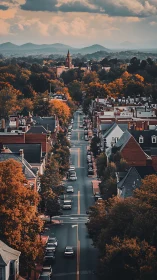 Autumn city avenue leads toward distant mountain horizon.