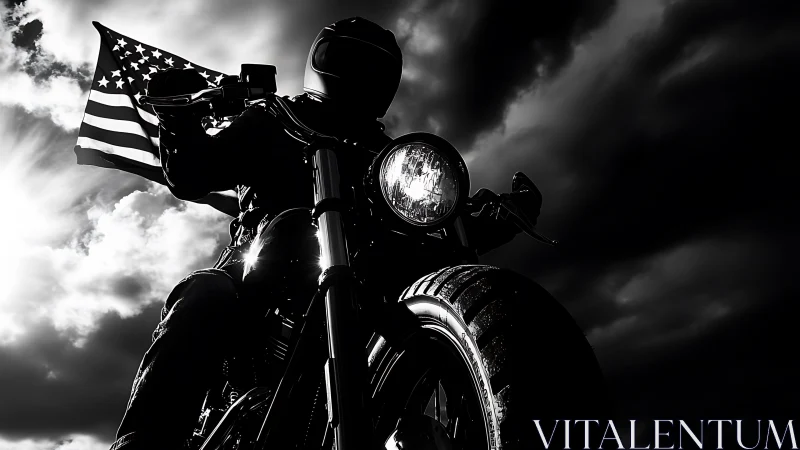 Motorcyclist holding US flag against dramatic cloudy sky.
