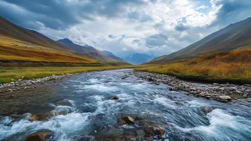 River rushes toward storm-kissed mountains under vast skies