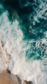 Overhead view shows waves breaking on sandy shoreline