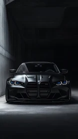 Matte black BMW M4 front view under controlled tunnel lighting