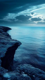 Storm-lit sea cliff under dramatic twilight sky.