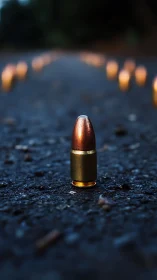 Single upright bullet on asphalt surface with blurred lights.