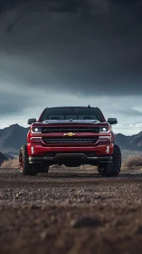 Red off-road pickup dominates stormy desert landscape.