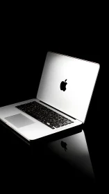 Sleek silver laptop glows against a deep black backdrop.
