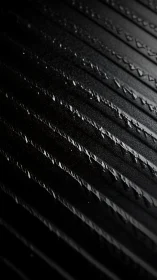 Gleaming raindrops trace quiet paths across dark metal lines