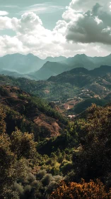 Mountain valley landscape shows layered ridges and clouds