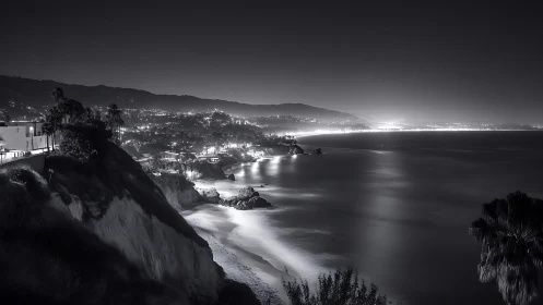 Long-exposure monochrome coastal cityscape with illuminated shoreline