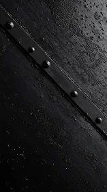 Diagonal riveted steel strip across wet textured metal plane