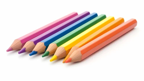 Row of sharpened colored pencils lies on white surface