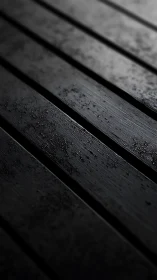 Dark wet wooden planks in shallow focus perspective.