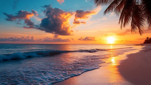 Tropical beach sunset with clouds, surf and palm silhouettes.