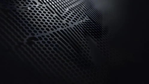 Abstract metallic surface with perforated dot pattern and dark tones.
